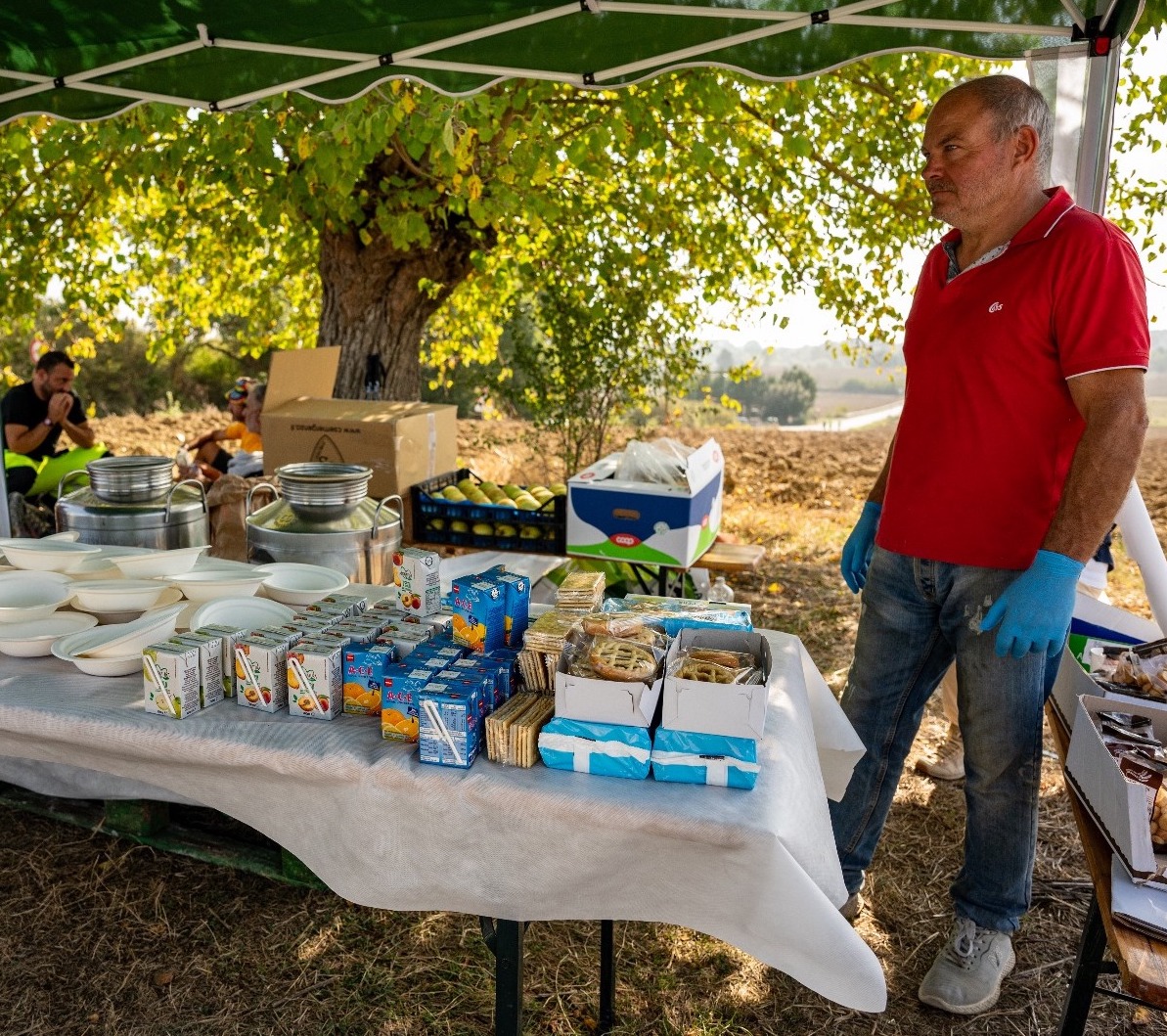 Volontario affianco a tavolo di cibo.