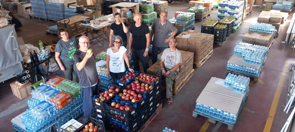 Gruppo di persone intorno a cassette di frutta e pancali intorno