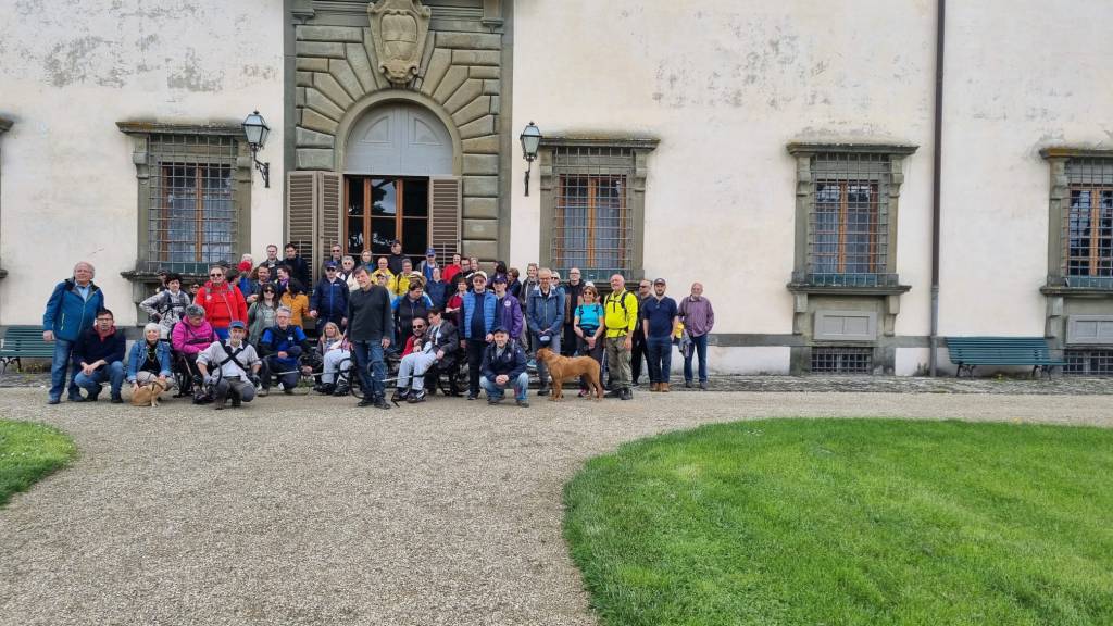 Gruppo di persona di fronte all'entrata a palazzo monumentale.